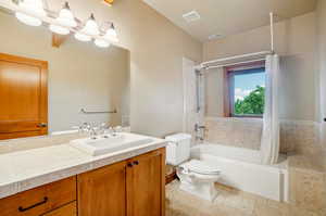 Full bathroom featuring tile patterned floors, vanity, shower / bathtub combination with curtain, and toilet