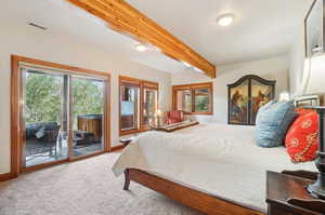 Carpeted bedroom featuring beam ceiling and access to outside