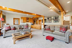 Living room featuring beam ceiling and light colored carpet