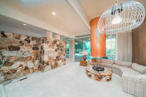 Living room featuring a textured ceiling, carpet, and plenty of natural light