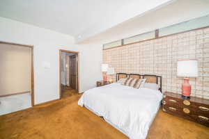 Carpeted bedroom featuring a textured ceiling and beam ceiling