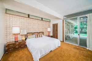 Bedroom with beamed ceiling, a closet, access to exterior, a textured ceiling, and carpet flooring