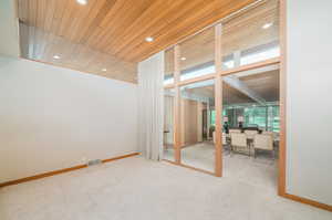 Interior space with wood ceiling and light carpet