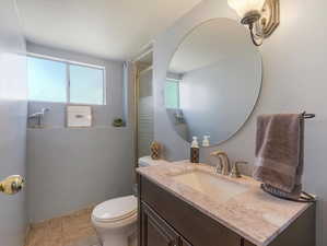 Bathroom with vanity, toilet, and tile patterned floors