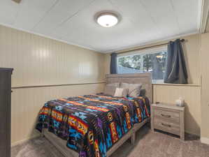 Carpeted bedroom featuring crown molding