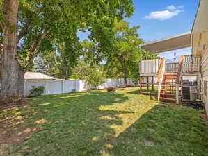 View of yard with cooling unit and a deck