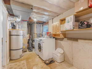 Laundry area featuring washer and dryer, cabinets, and water heater