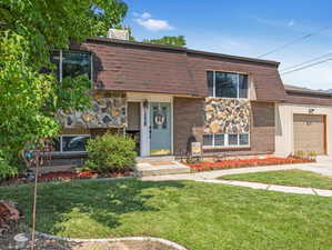 View of front of property with a garage and a front lawn