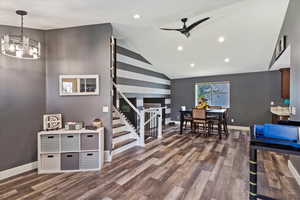 Interior space featuring lofted ceiling, ceiling fan with notable chandelier, and hardwood / wood-style floors