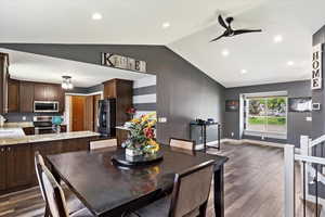 Dining space featuring sink, dark hardwood / wood-style floors, ceiling fan, and vaulted ceiling