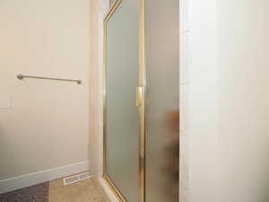 Bathroom featuring walk in shower and tile patterned flooring