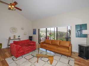 Living room featuring light hardwood / wood-style flooring, high vaulted ceiling, and ceiling fan