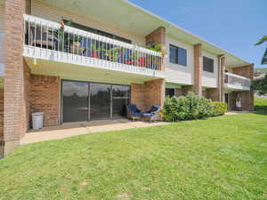 Back of property with a balcony, a yard, and a patio area