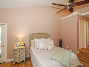 Bedroom with lofted ceiling, light hardwood / wood-style flooring, and ceiling fan