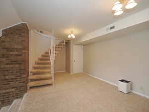 Basement with a notable chandelier and carpet floors