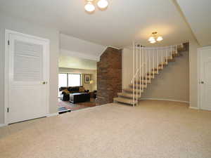 Interior space featuring carpet and brick wall