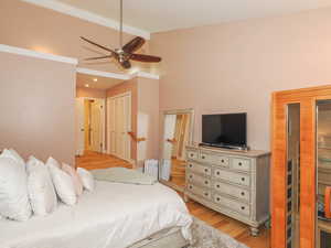 Bedroom featuring light hardwood / wood-style floors, lofted ceiling, and ceiling fan