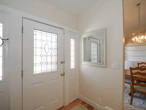 Foyer entrance featuring a notable chandelier and hardwood / wood-style floors