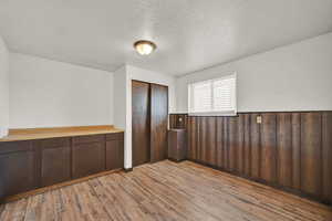 Unfurnished room featuring a textured ceiling and light wood-type flooring