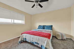 Carpeted bedroom featuring ceiling fan