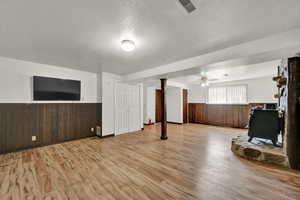 Interior space featuring light wood-type flooring, ceiling fan, and a textured ceiling