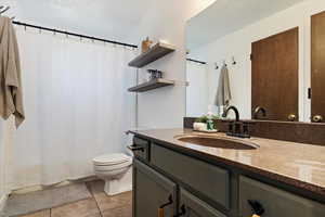 Bathroom with vanity, tile patterned flooring, and toilet