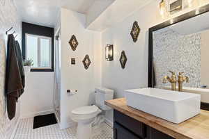 Bathroom featuring vanity, tile patterned flooring, and toilet