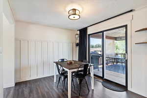 Dining space featuring ornamental molding, a textured ceiling, and dark hardwood / wood-style floors