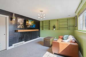 Sitting room with a notable chandelier, carpet, and a textured ceiling