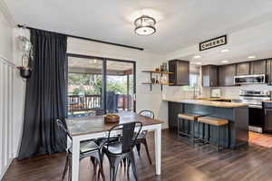 Dining space with sink, a wealth of natural light, and dark wood-type flooring