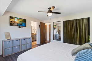 Bedroom featuring ensuite bath, ceiling fan, and dark hardwood / wood-style flooring