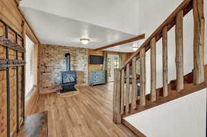 Foyer entrance featuring a wood stove, light hardwood / wood-style floors, and brick wall