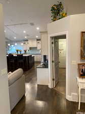 Kitchen with pendant lighting, dark hardwood / wood-style floors, a kitchen breakfast bar, and backsplash