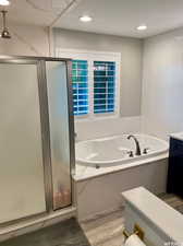 Bathroom with vanity, hardwood / wood-style flooring, and separate shower and tub