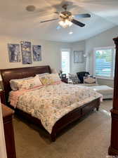 Bedroom with vaulted ceiling, ceiling fan, and carpet flooring