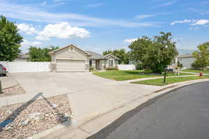 Ranch-style home featuring a garage and a front lawn