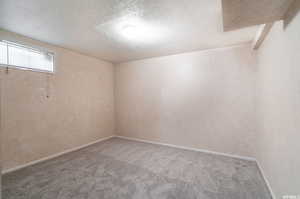 Carpeted empty room featuring a textured ceiling