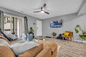 Living room with light wood-type flooring and ceiling fan