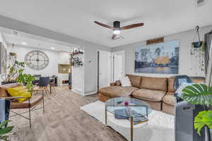 Living room with light wood-type flooring and ceiling fan