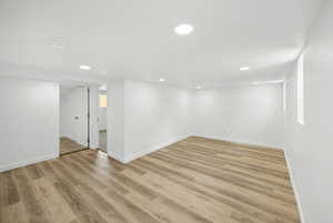 Basement living room featuring light hardwood / wood-style flooring