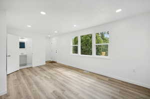 Unfurnished living room with sink and light wood-type flooring