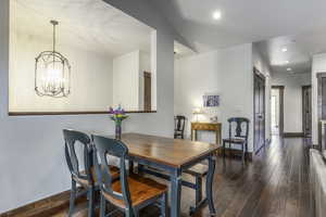 Dining area with dark hardwood / wood-style floors and a chandelier