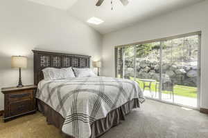 Bedroom featuring access to exterior, light colored carpet, vaulted ceiling, and ceiling fan