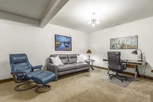 Carpeted office featuring beamed ceiling