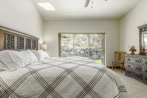 Bedroom featuring ceiling fan, access to exterior, and light carpet