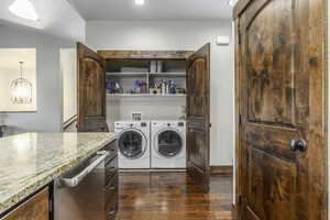 Washroom with dark hardwood / wood-style floors and separate washer and dryer