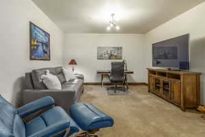 Office area featuring a notable chandelier and light colored carpet