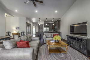 Living room featuring ceiling fan and dark wood-type flooring