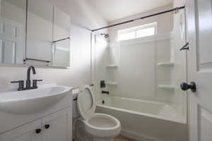 Full bathroom featuring toilet, vanity, and washtub / shower combination