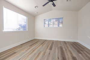 Unfurnished room featuring lofted ceiling, light hardwood / wood-style flooring, and ceiling fan